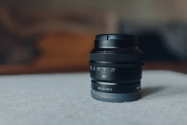 London, UK - May 07, 2021: Close up of a Sony 40mm compact lens, selective focus. It is a part of new line up of compact primes recently announced by Sony. - Photo, Image
