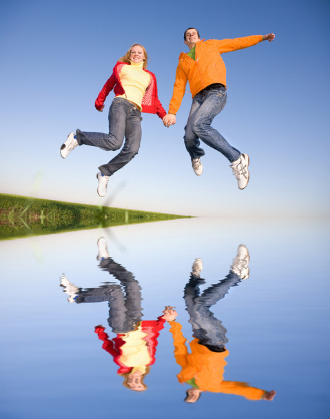 Happy young couple jumping in sky - Photo, Image