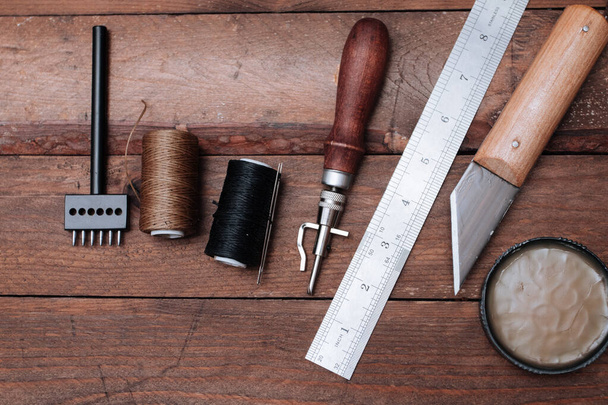 Συλλογή δερμάτινων εργαλείων χειροτεχνίας. Εργαλεία τσαγκάρης σε ξύλινο τραπέζι - Φωτογραφία, εικόνα