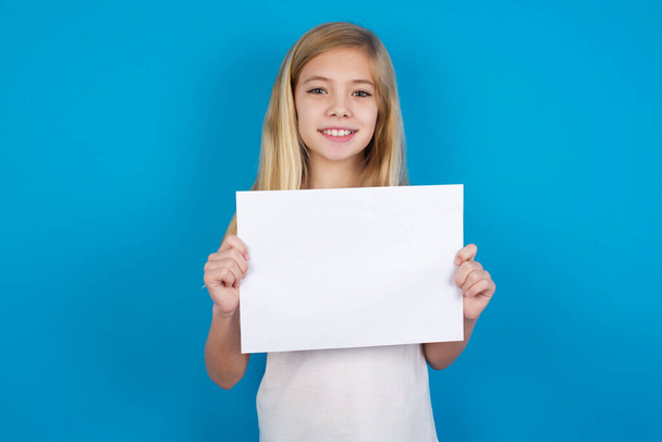 Ευτυχισμένο όμορφο καυκάσιο κορίτσι φορώντας t-shirt Holding Empty Paper Board Διαφήμιση Προσφορά κειμένου Μόνιμη. Διαφημιστικό Banner Φθινοπώρου. - Φωτογραφία, εικόνα
