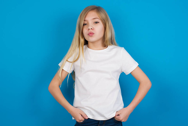 Porträt der schönen lustigen schönen kaukasischen Mädchen trägt T-Shirt Senden Luftkuss - Foto, Bild
