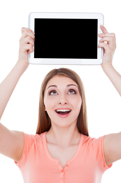Mujer sosteniendo tableta digital sobre la cabeza
 - Foto, imagen