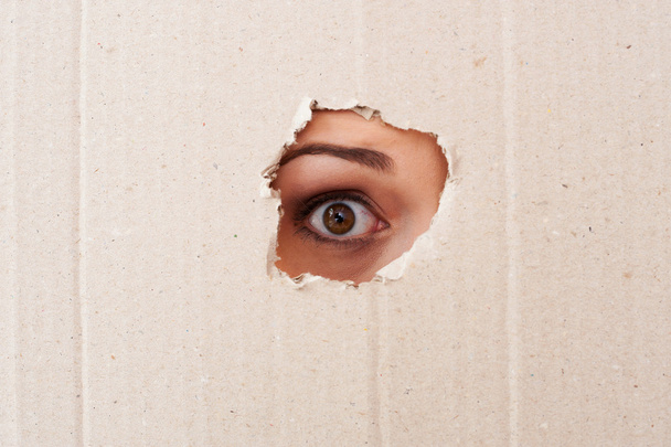 Eye looking through a hole - Fotografie, Obrázek