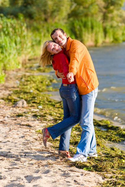 μικρά αγάπη ζευγάρι αγκαλιά στην ακτή του ποταμού - Φωτογραφία, εικόνα