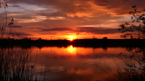 Geweldige zonsondergang of zonsopgang boven een meer. Reflectie van wolken en lucht in het water. Oranje kleurrijk landschap. - Video