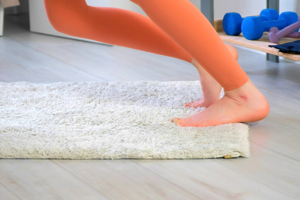 Woman warming her feet practicing youga doing exercises at home, closeup legs. - Zdjęcie, obraz