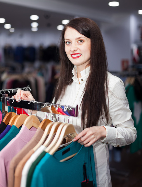 Happy young woman choosing clothes - 写真・画像