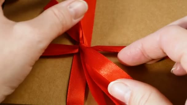 Подарочная коробка с лентой красный лук, коричневый картонный пакет, сюрприз - Кадры, видео
