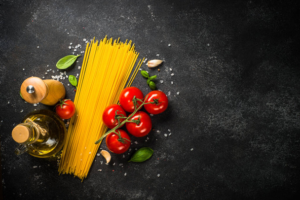 Pasta background. Pasta spaghetti, olive oil, spices, basil and fresh tomatoes. - Foto, Bild