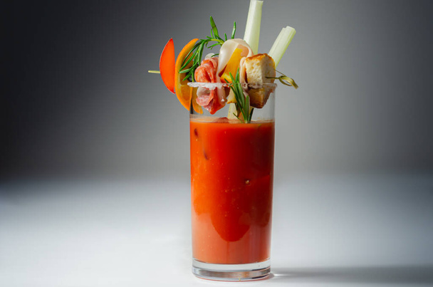 Bloody Mary with interesting decoration with a small snack on top of a cocktail glass, freshness drink - Foto, Imagem