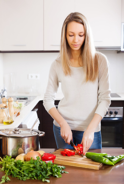 Casual blonde woman slicing red pepper   - Photo, Image