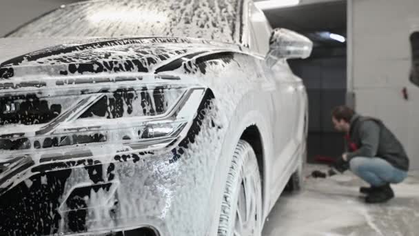 İşçi araba jantlarını şampuanlı yumuşak bir fırçayla yıkıyor. - Video, Çekim