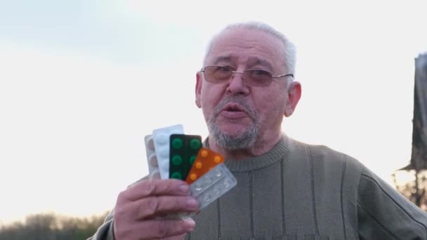 Großvater mit Tabletten in der Hand. Glücklicher Mann im Rentenalter - Filmmaterial, Video