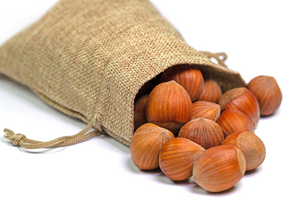 Lískové ořechy v jutovém sáčku na bílém pozadí - Fotografie, Obrázek