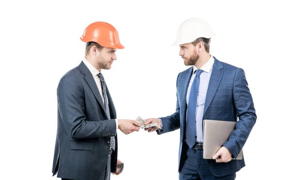 men businessmen in hardhat with money and laptop. architect take dollars cash. bribery and corruption. loans for planned investments in future. financial support. investment in architectural project. - Фото, зображення
