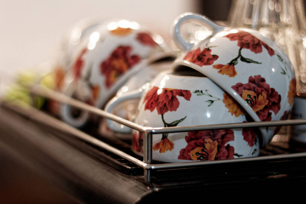 The collection of glasses on the coffee machine is arranged in a beautiful floral pattern, perfect for coffee lattes to accompany cold nights. - Foto, Imagem