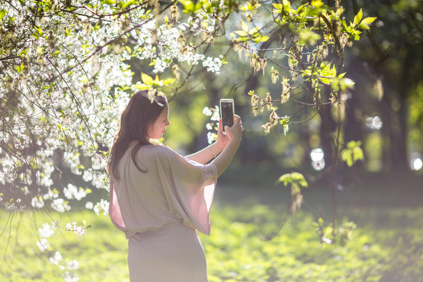 Belle jeune femme dans le jardin des fleurs de cerisier - Photo, image