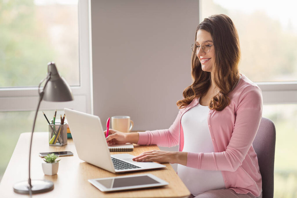 Profile side view portrait of lovely smart cheerful pregnant girl staying home writing esssay work article free time in flat house indoors - Photo, image