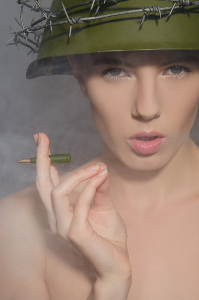 Female soldier in helmet with bullet-cigarette - Fotografie, Obrázek