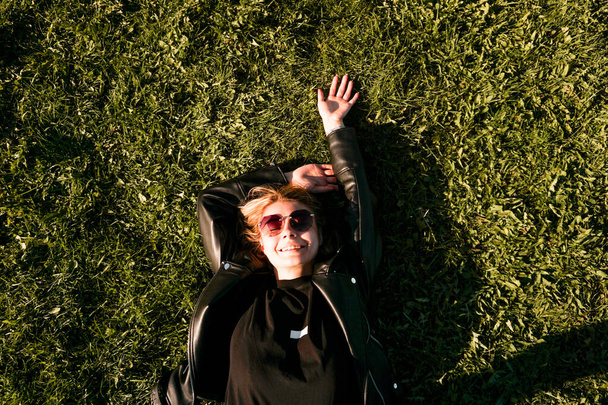 Beautiful healthy Young Woman lying and relaxing on the green grass - Foto, immagini