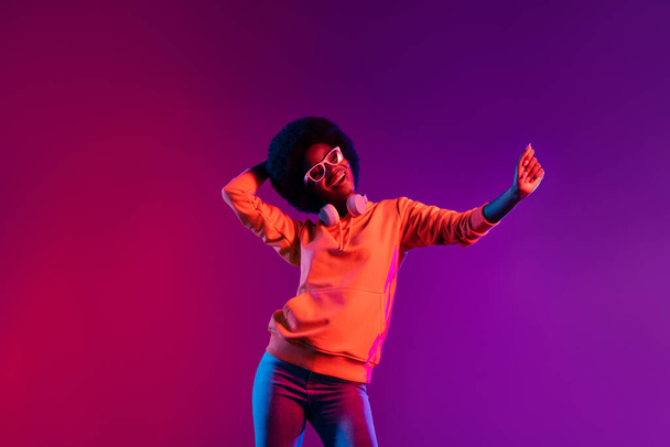 Photo of carefree cheerful dark skin young girl dancing have fun partying isolated on vibrant background - Fotoğraf, Görsel