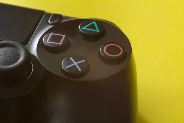 Nahaufnahme eines weißen Joypads vor gelbem Hintergrund, Konzept des Videospiels. - Foto, Bild