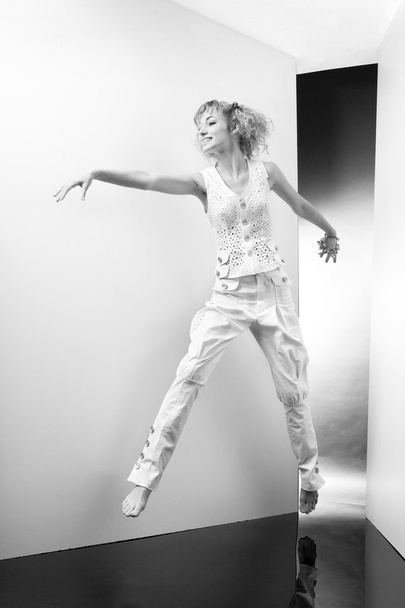 Jonge vrouw springt en plezier in de studio - Foto, afbeelding