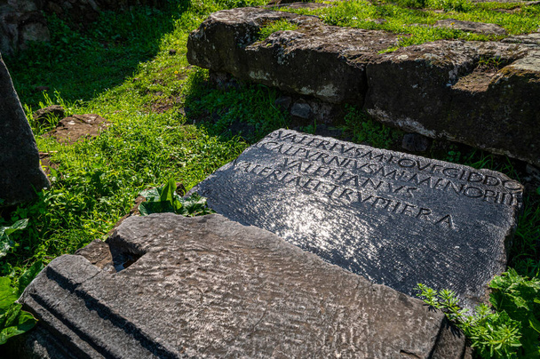 Inscription d'une tombe sur l'ancienne Appia rayonnée par les rayons du soleil après la tempête chatoyante immergée dans le vert Rome Italie Europe. - Photo, image