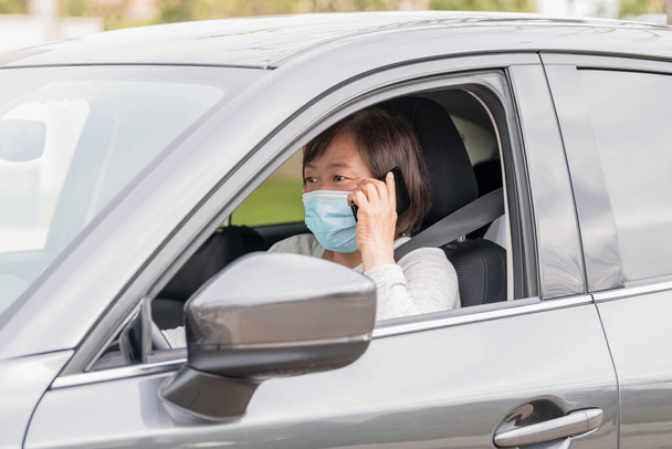 maturo asiatico donna in un auto parlando su il suo telefono selettivo messa a fuoco. - Foto, immagini