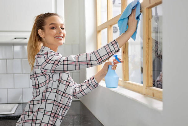 Smiling Woman Washing Window with Sponge Rag, Cleaning Window, Wiping Dirt - Foto, imagen