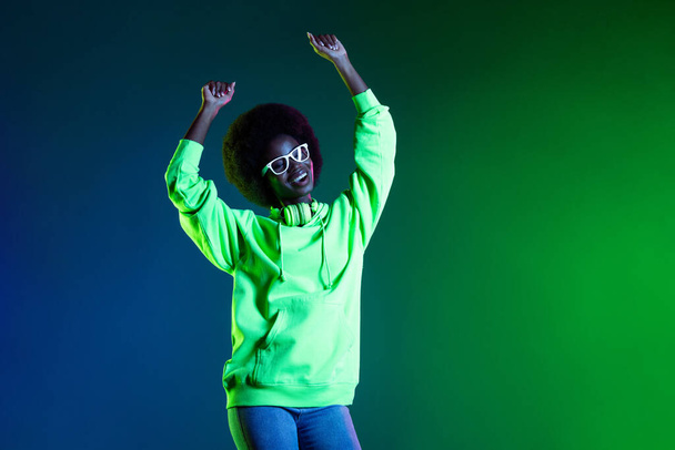 Photo of funny pretty dark skin lady raise hands dancing have good mood isolated on vivid color background - Zdjęcie, obraz