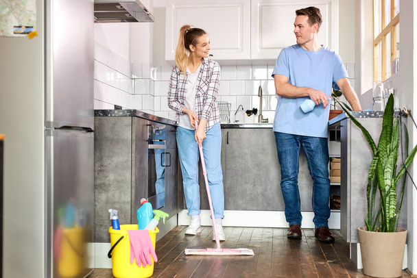 Young Nice Janitors Cleaning Kitchen And Mopping Floor At Home - Foto, Bild