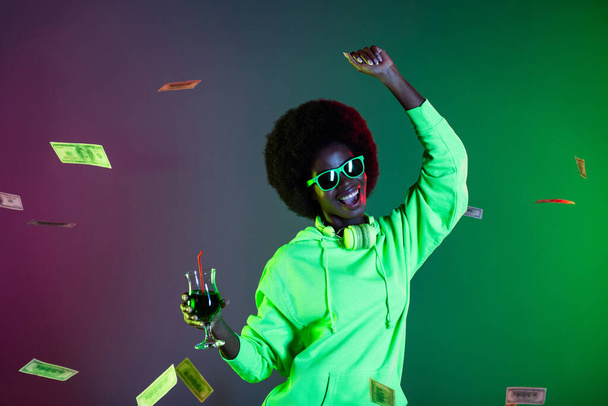 Photo of 90s style lady dance drink cocktail have fun wear sunglass hoodie isolated gradient green neon background - Photo, image