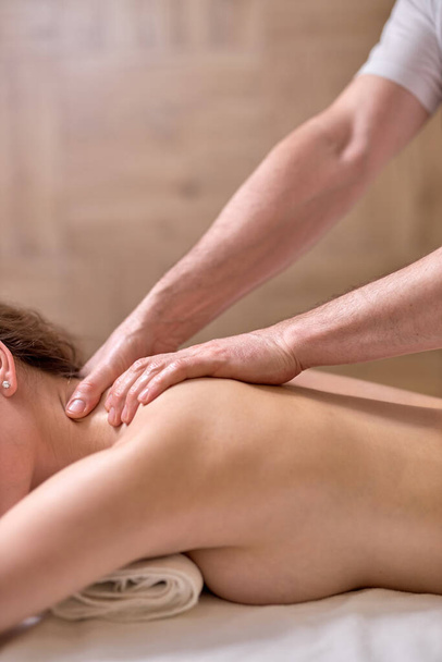 Massagem nas costas para jovem do sexo feminino no moderno salão de spa. Recuperação muscular após o exercício. Bem-estar. Tratamento das costas. massagem desportiva. - Foto, Imagem