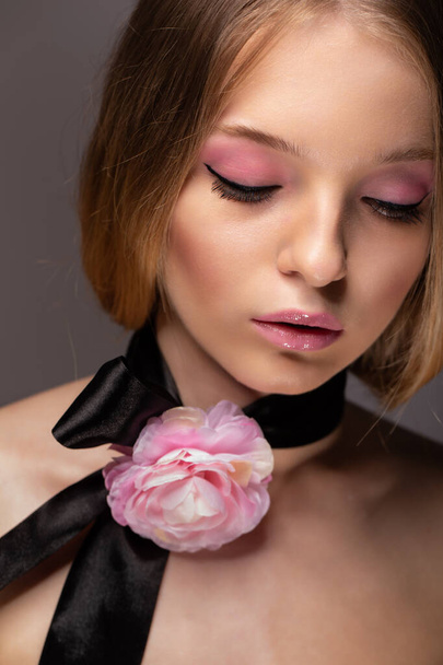 Beautiful woman with natural make-up and flowers decoration on her neck - Foto, Bild