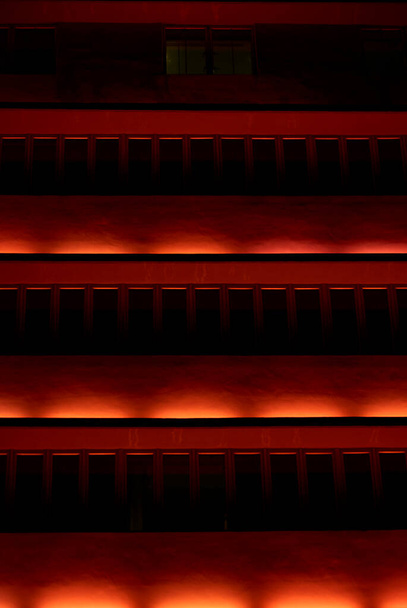 Punainen valaistu moderni rakennus julkisivu yöllä - Valokuva, kuva