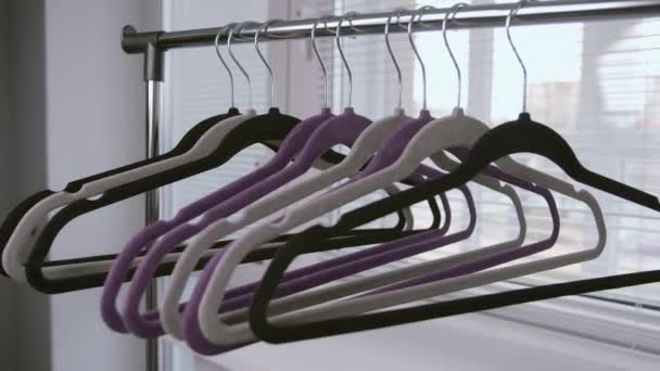 Homme prend un cintre de vêtements vides du rack tout en suivant la caméra, fond lumineux - Séquence, vidéo