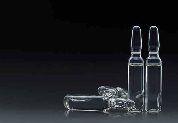 medische ampullen van glas op donkere achtergrond - Foto, afbeelding