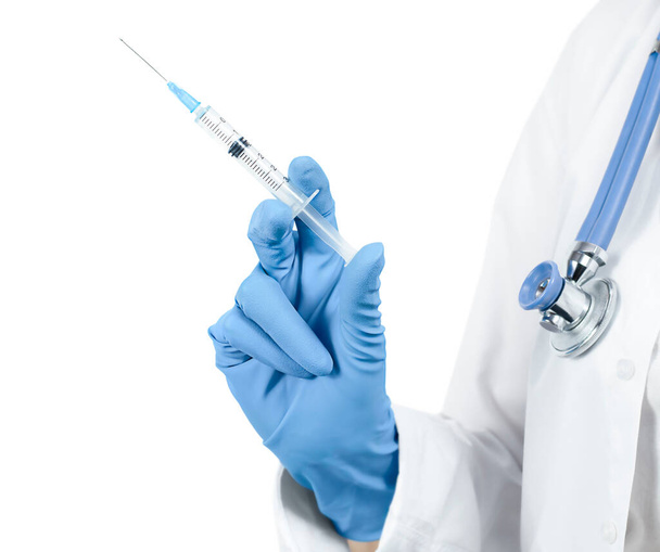 Врач держит шприц с жидкостью на белом изолированном фоне. концепция вакцинации - Фото, изображение