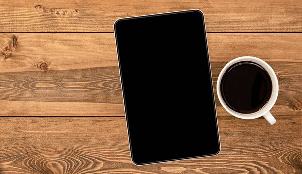 tablet computer and coffee cup on wooden table - Photo, Image