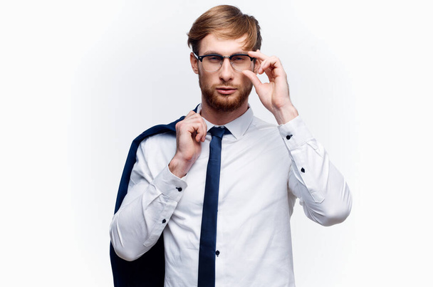 бизнесмен в очках с пиджаком на плече и галстуком - Фото, изображение