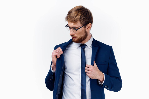Sarışın, gözlüklü ve klasik takım elbiseli bir adam kravatını boynuna ve ceketine dolamış. - Fotoğraf, Görsel