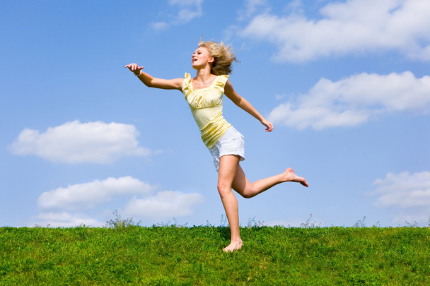 Happy young woman is running in a field - Photo, image