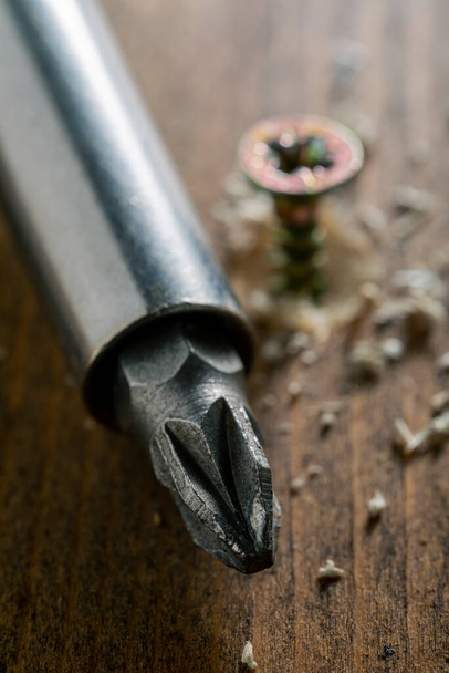 Self-tapping screw screwed into a wooden board close-up. Screw for wood - Fotografie, Obrázek