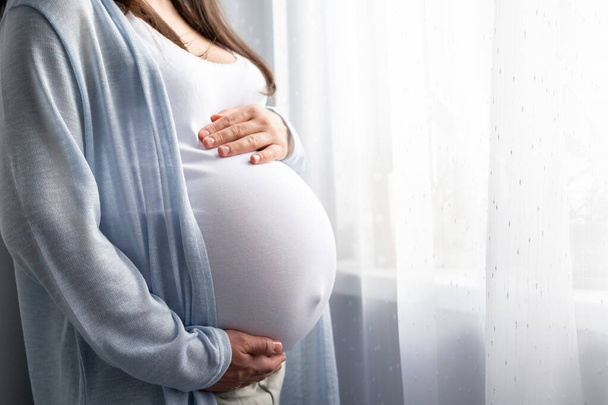 healthy pregnancy. Side view pregnant woman with big belly advanced pregnancy in hands. Banner copyspace for text. Elegant mother waiting baby. - Foto, Imagem