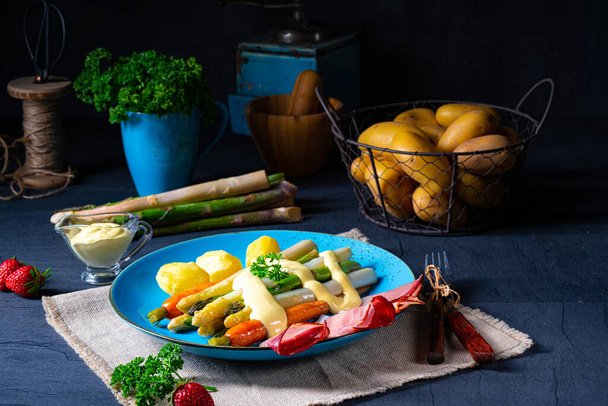 Asparagus with black forest ham, carrots and hollandaise sauce. - Foto, Imagen