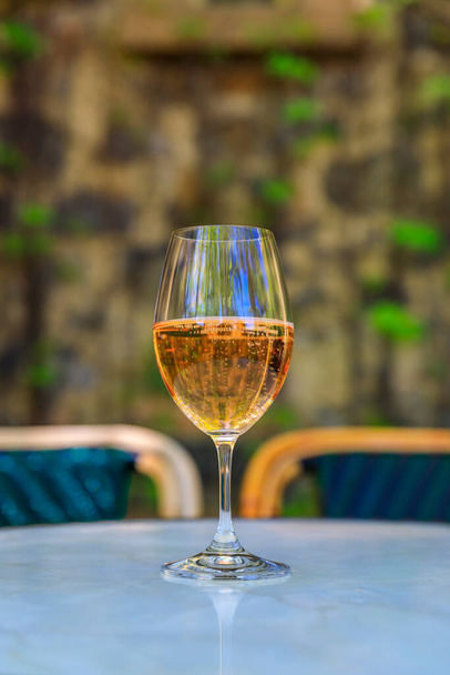 Ποτήρι αφρώδες κρασί τριαντάφυλλο εξωτερική με θολή φόντο στην κοιλάδα Νάπα, Καλιφόρνια, ΗΠΑ - Φωτογραφία, εικόνα