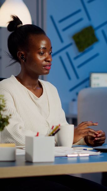 Gerente africano hablando en línea con compañeros de trabajo a distancia utilizando el ordenador portátil - Foto, imagen