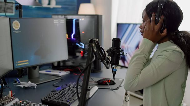 African woman streamer cyber putting on headphones - Photo, image