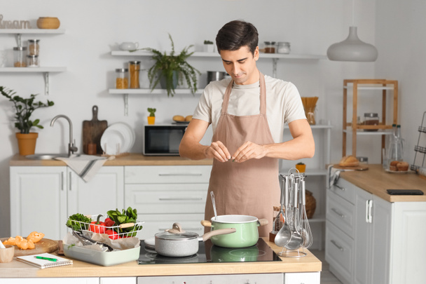 Nuori mies ruoanlaitto keittiössä - Valokuva, kuva
